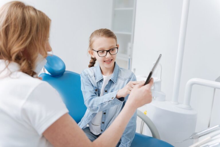 Clever competent dentist using tablet during consultation